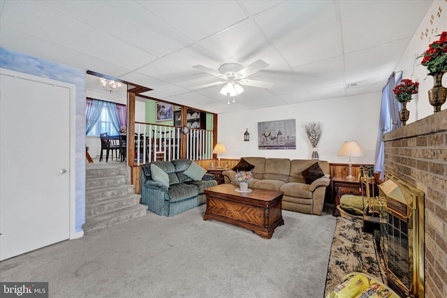 carpeted living room featuring ceiling fan and a fireplace