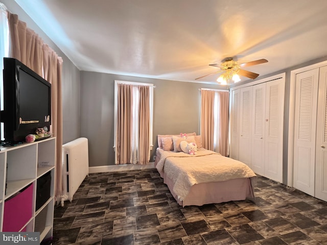 bedroom featuring multiple closets, ceiling fan, and radiator