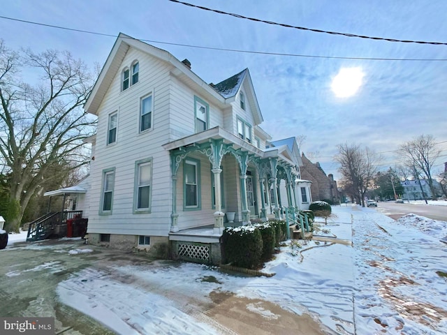 snow covered property featuring a porch