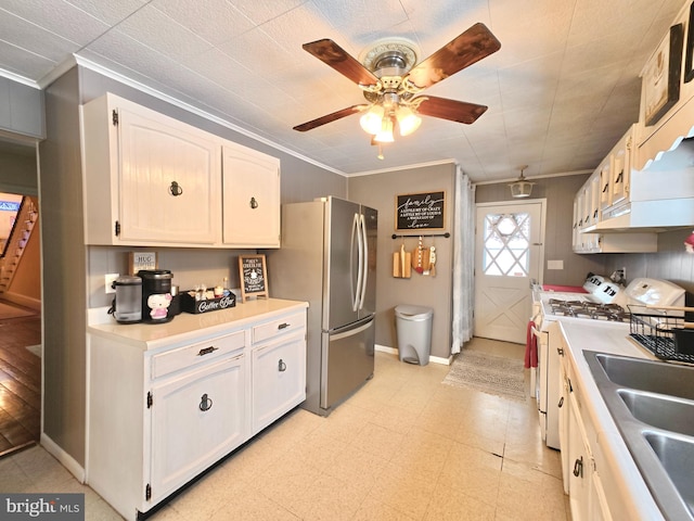 kitchen featuring crown molding, sink, range, and white cabinets