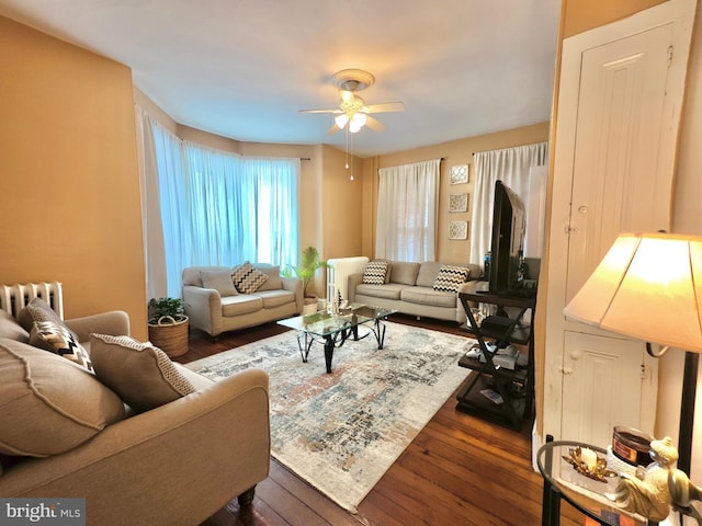 living room with dark wood-type flooring and ceiling fan