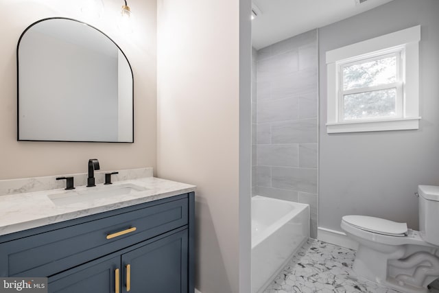 full bathroom featuring tiled shower / bath, vanity, and toilet