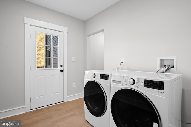 clothes washing area featuring light hardwood / wood-style floors and washing machine and dryer