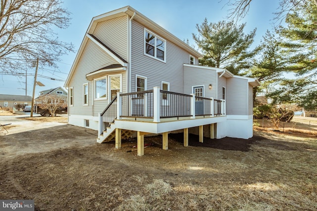 rear view of property featuring a wooden deck