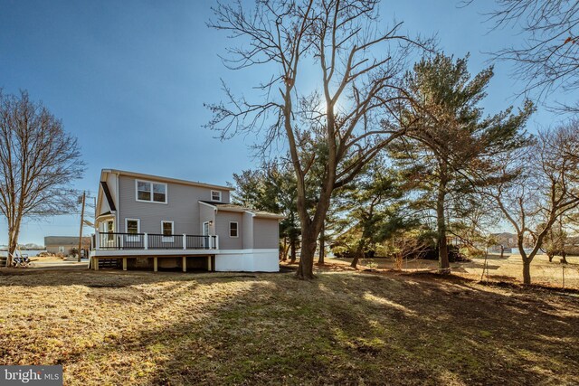 back of house featuring a deck and a lawn