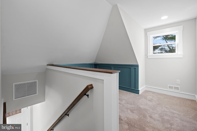 stairway featuring lofted ceiling and carpet