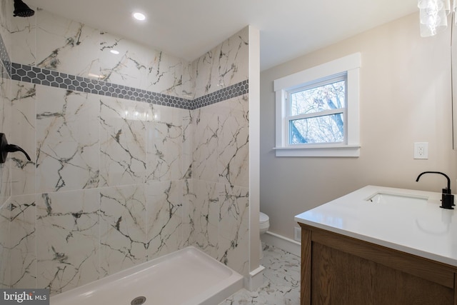 bathroom featuring vanity, toilet, and a tile shower