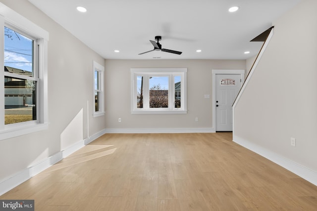 unfurnished living room featuring light hardwood / wood-style flooring and ceiling fan