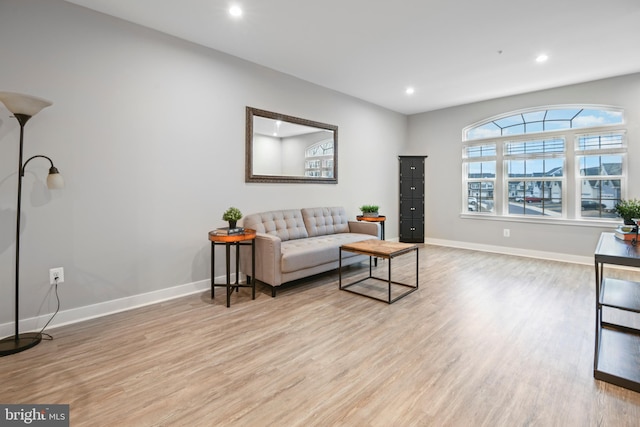 living area featuring baseboards, wood finished floors, and recessed lighting