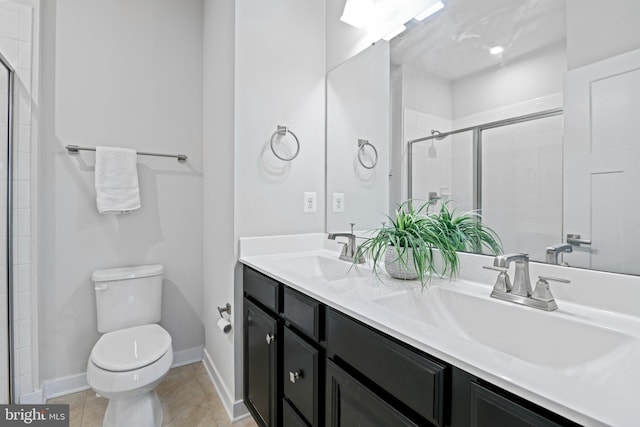 bathroom with toilet, tile patterned flooring, a sink, and tiled shower