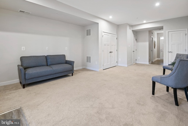 living area featuring recessed lighting, visible vents, light carpet, and baseboards