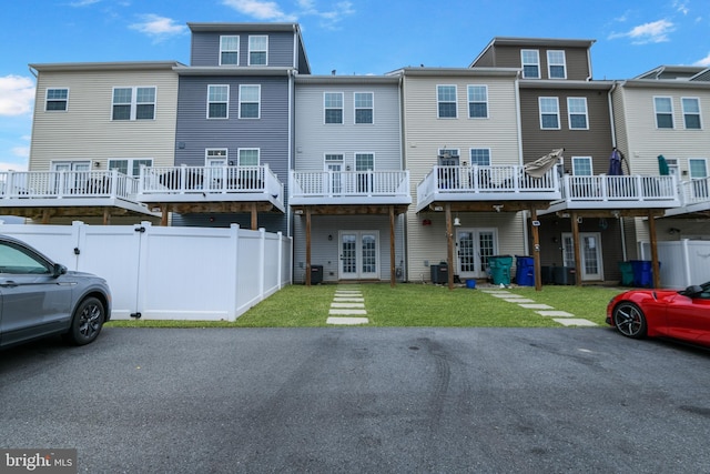 rear view of property featuring french doors, central AC, a yard, and fence