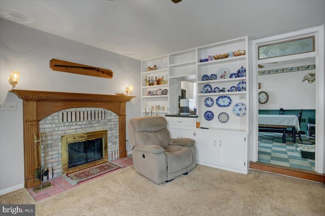 sitting room featuring a brick fireplace, built in features, and light colored carpet