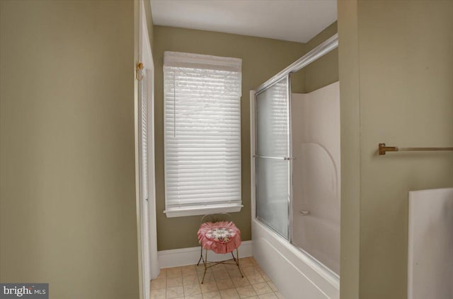 bathroom featuring tile patterned flooring, a wealth of natural light, and bath / shower combo with glass door