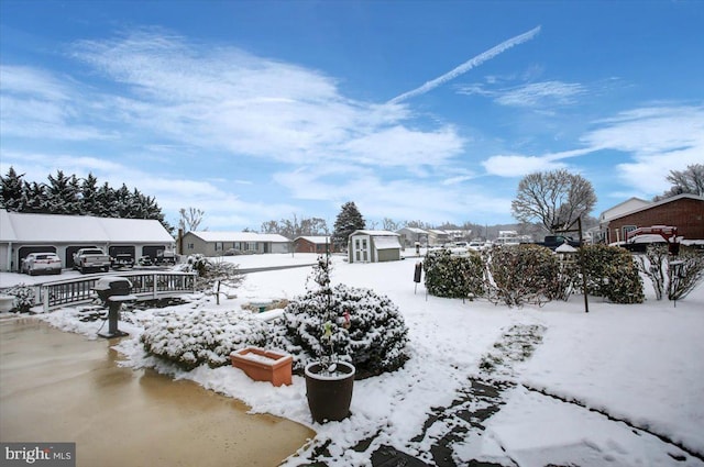 yard layered in snow featuring a storage shed