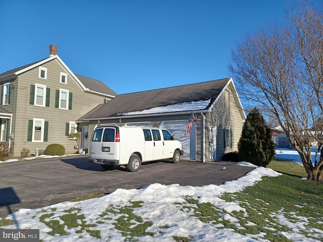 view of snow covered exterior with a garage