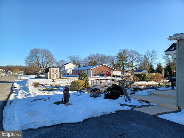 yard layered in snow with a deck and a shed