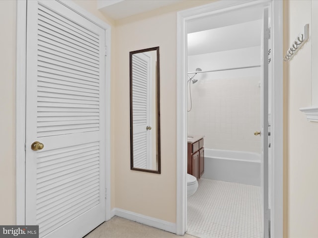 bathroom with tile patterned floors, toilet, and tiled shower / bath combo