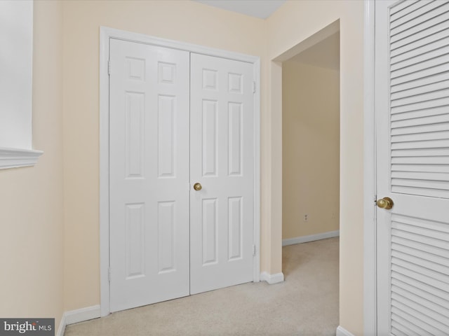 interior space with light carpet and a closet