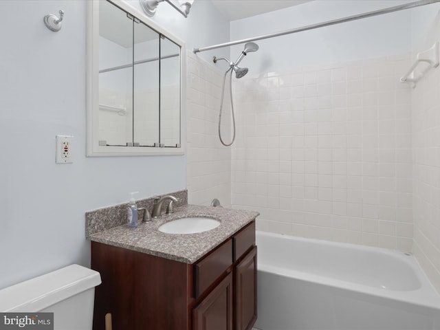 full bathroom with vanity, tiled shower / bath, and toilet