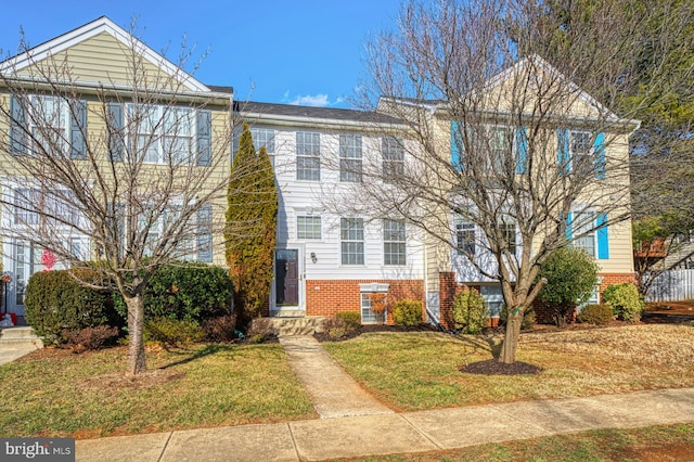 townhome / multi-family property featuring a front yard