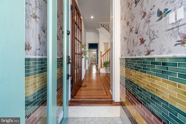 hallway featuring tile walls and light tile patterned floors