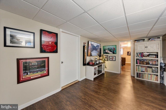 interior space with dark hardwood / wood-style flooring and a paneled ceiling