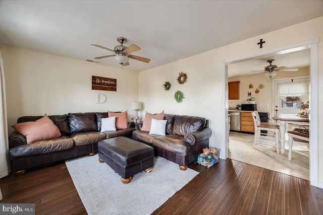 living room with dark wood-type flooring and ceiling fan