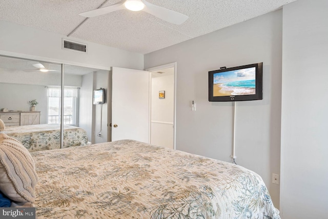 bedroom with ceiling fan, a closet, and a textured ceiling