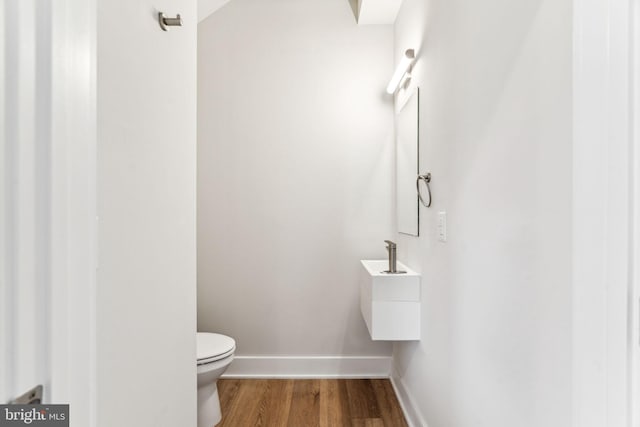 bathroom with hardwood / wood-style flooring and toilet