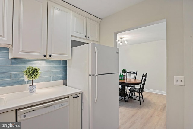 kitchen featuring decorative backsplash, light countertops, white appliances, white cabinetry, and light wood-type flooring