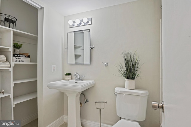 bathroom featuring baseboards and toilet