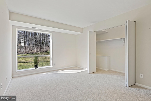 unfurnished bedroom featuring baseboards, visible vents, a closet, and carpet floors