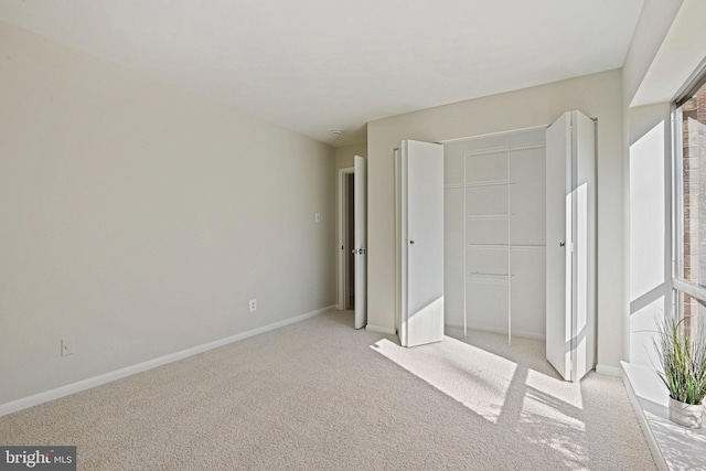 unfurnished bedroom with multiple windows, a closet, light carpet, and baseboards