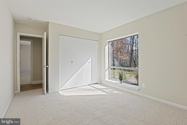 unfurnished bedroom featuring baseboards, a closet, and carpet