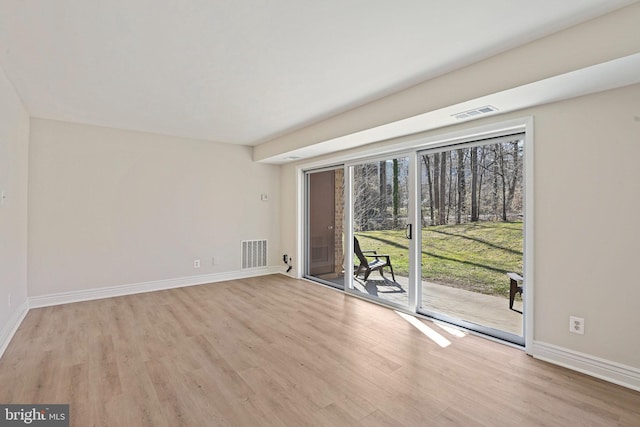 spare room featuring baseboards, light wood finished floors, and visible vents