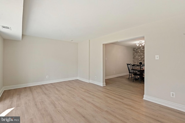spare room with baseboards, visible vents, and light wood-style floors