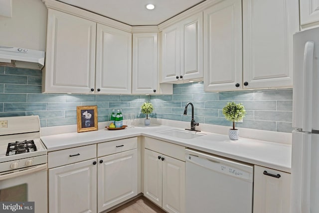 kitchen featuring a sink, tasteful backsplash, under cabinet range hood, and white appliances