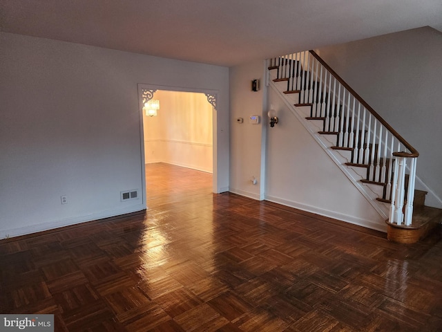 unfurnished living room with dark parquet flooring