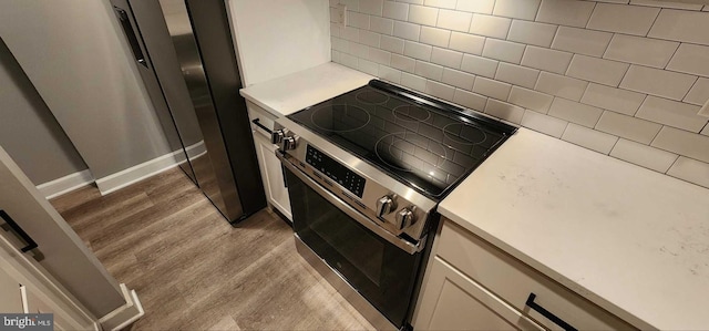 kitchen featuring tasteful backsplash, electric range, dark hardwood / wood-style floors, and white cabinets