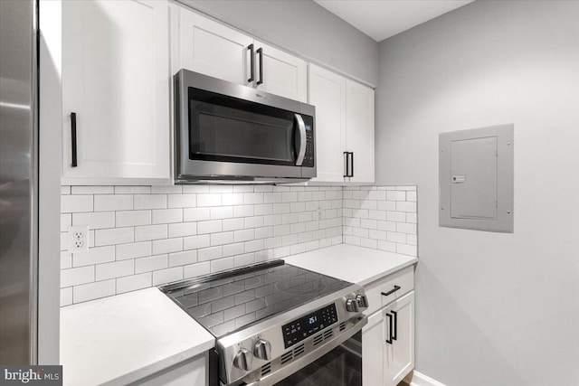 kitchen featuring white cabinetry, stainless steel appliances, electric panel, and decorative backsplash