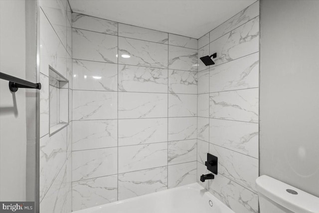 bathroom featuring toilet and tiled shower / bath