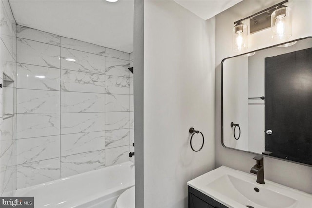 full bathroom featuring vanity, tiled shower / bath combo, and toilet