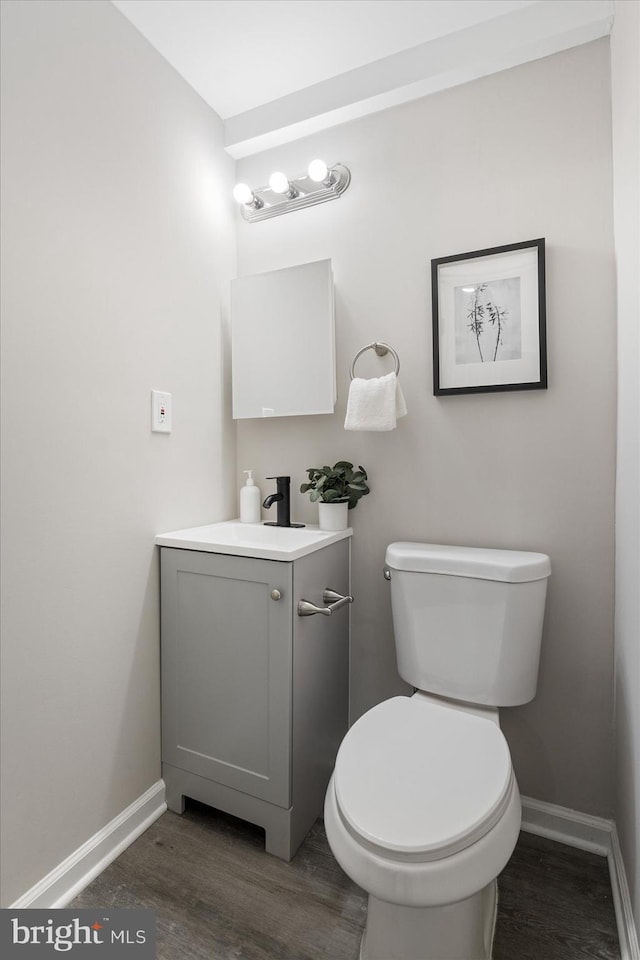 bathroom featuring hardwood / wood-style flooring, vanity, and toilet