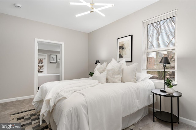 bedroom with carpet and ceiling fan with notable chandelier