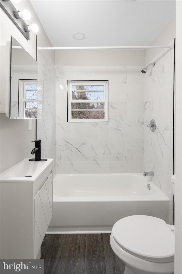 full bathroom featuring vanity, toilet, tiled shower / bath combo, and hardwood / wood-style floors