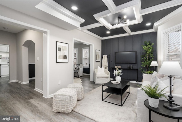 living room featuring hardwood / wood-style flooring, ornamental molding, coffered ceiling, and beam ceiling