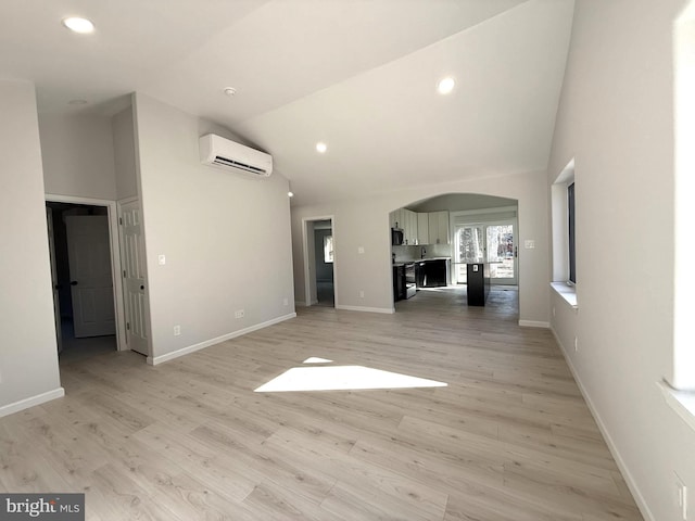 unfurnished living room featuring high vaulted ceiling, light wood-type flooring, and a wall unit AC