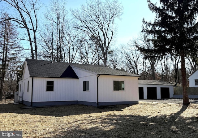 rear view of house featuring a garage and an outdoor structure