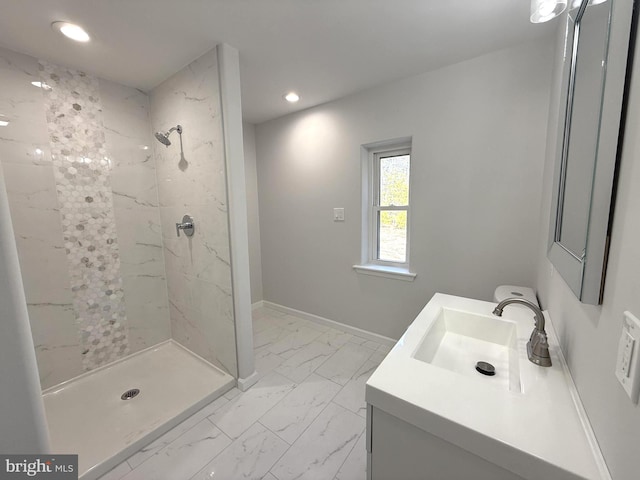 bathroom featuring tiled shower and vanity